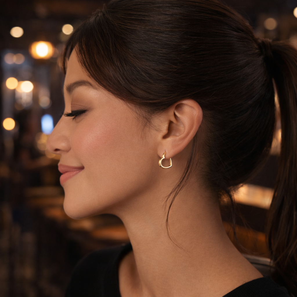 Woman wearing a gold hoop earring with a blurred background