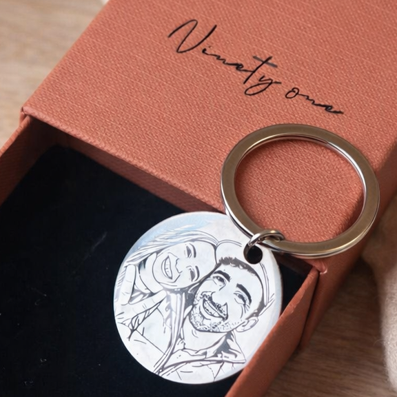 Keychain with engraved design in a brown box on a wooden surface