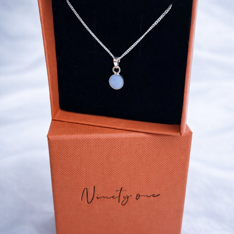 Necklace in a 'Ninety one' branded box on a light gray background