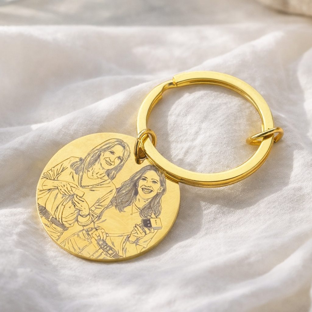 Gold keychain with engraved image on a white fabric background