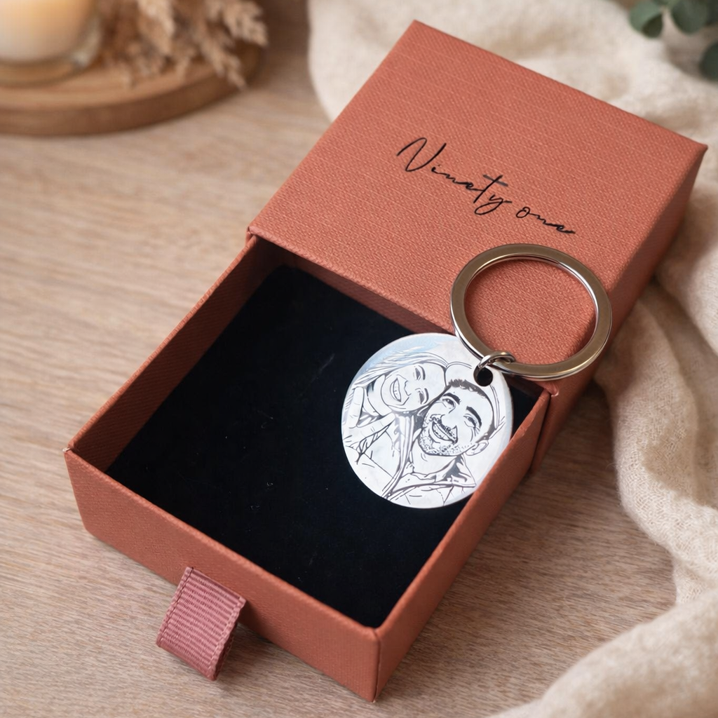 Keychain in a 'Ninety One' box on a wooden surface with a candle and plant in the background.